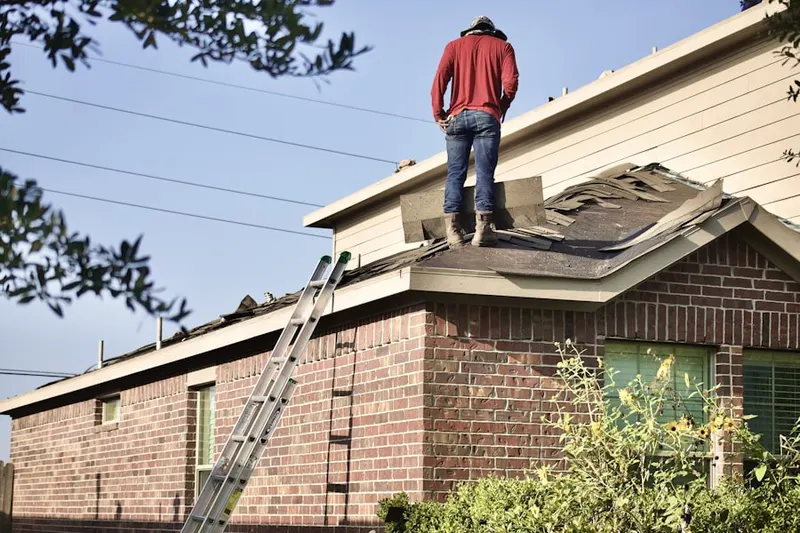 Professional roofer working on a residential roof in Vinco
